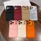 Collection of phone cases in various colors on a wooden surface