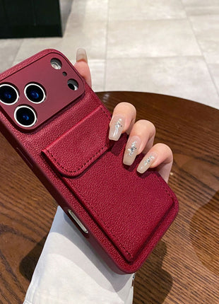 Red phone case with card holder held by a hand on a wooden table.