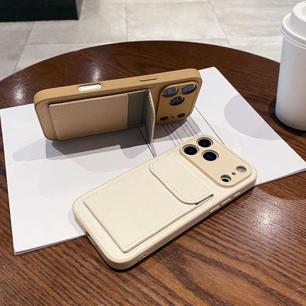 Two phone cases, one beige and one brown, on a wooden table with a white surface.