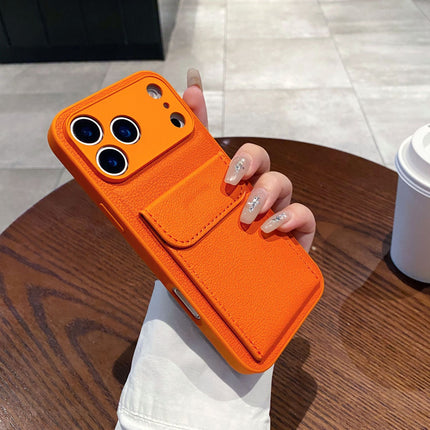 Orange phone case held by a hand on a wooden table with a blurred background