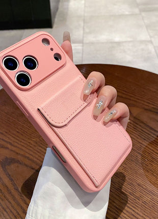 Pink phone case held by a hand on a wooden table with a blurred background