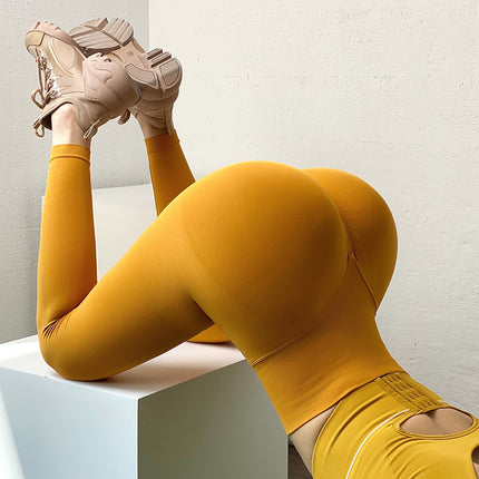 Person wearing mustard yellow leggings and shoes on a white background